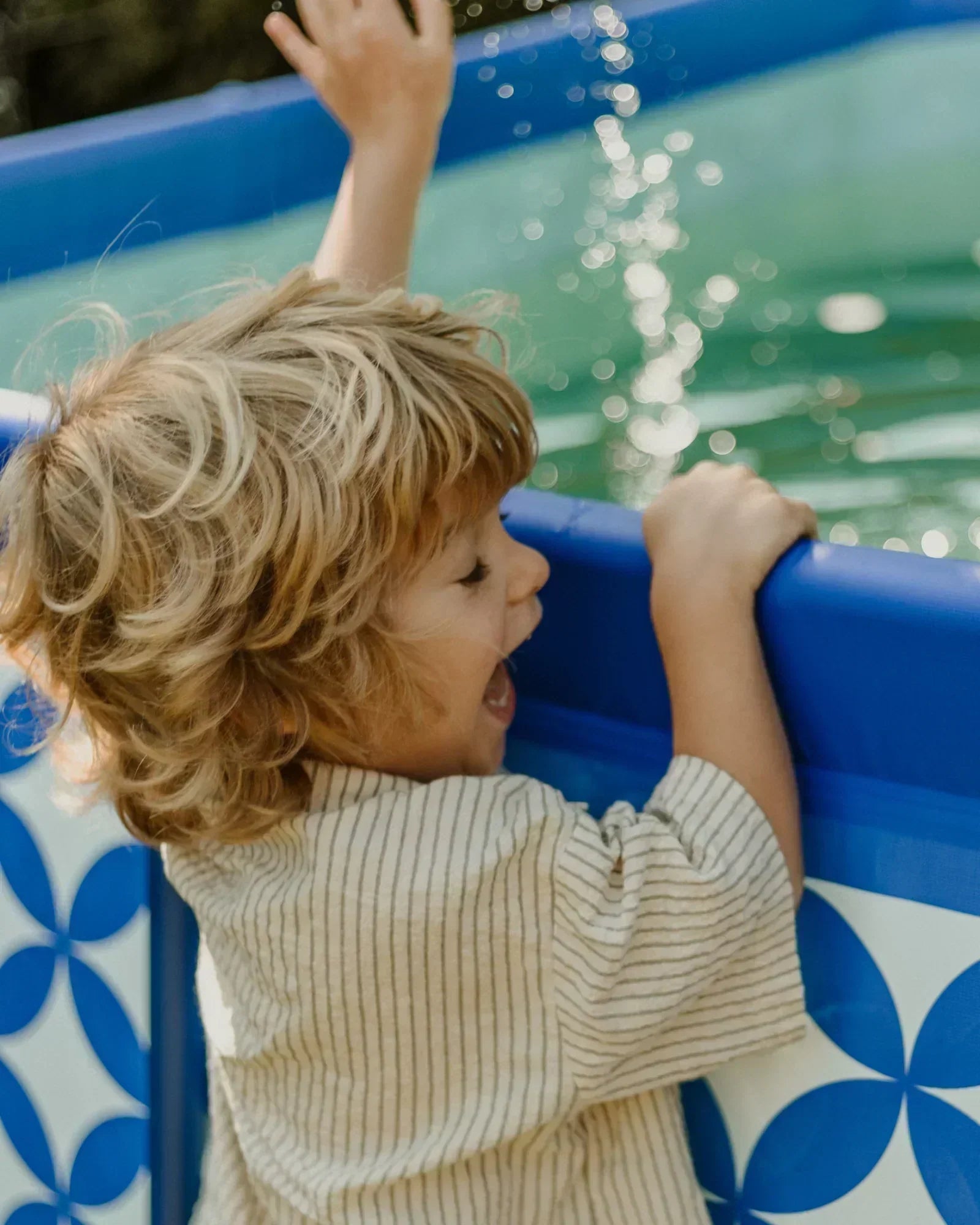 kid playing with water in pool