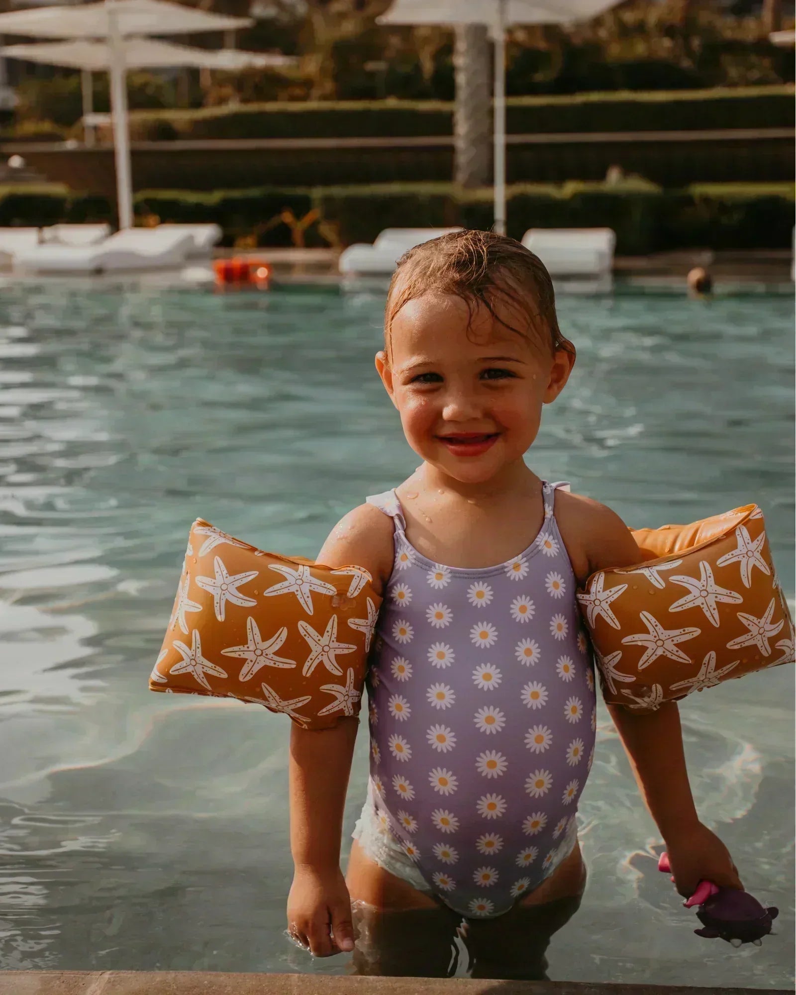 child with arm bands in water